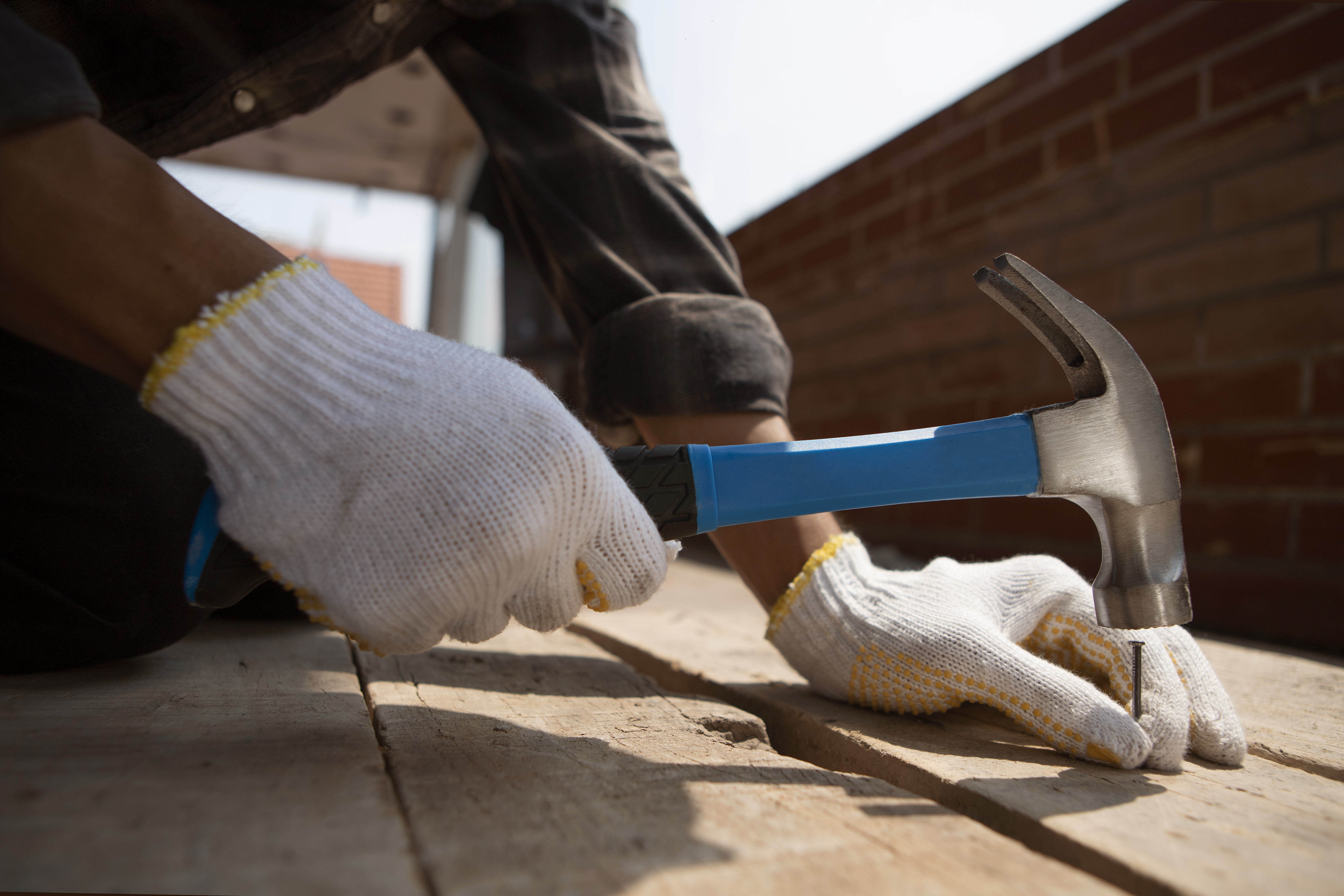 Operaio al lavoro con martello in cantiere